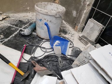 Araçlar ve çekiç, keski, cleaver, fırça, faraş ve eski fayans zemin üzerinde şerit metre ile bina onarım