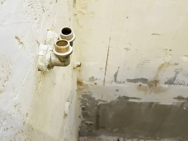 Fontanería y esquinas de latón en una pared de ladrillo y una tubería de propileno — Foto de Stock