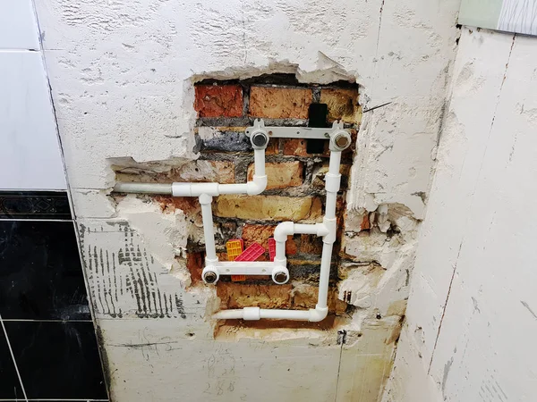 Propylenového potrubí a vrata v cihlové zdi - propylenu, svařování — Stock fotografie
