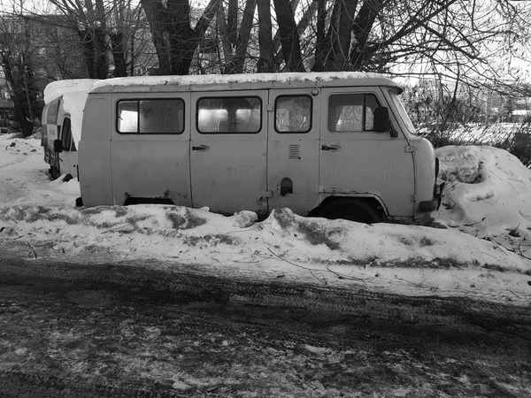 Старый неработающий автомобиль в снегу под деревом — стоковое фото