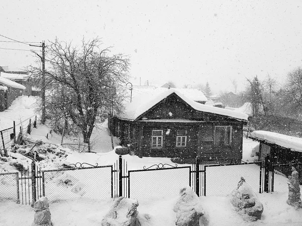 Красивий старий дерев'яний старовинний будинок у снігопаді — стокове фото