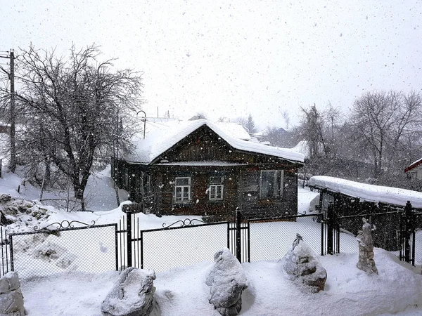 Beautiful old wooden vintage house in snowfall — Stock Photo, Image