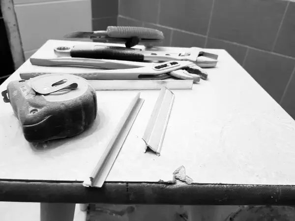 Επισκευή - κτίριο με γαλλικό κλειδί εργαλεία, μαχαίρι, μαχαίρι σιδήρου, ρυθμιζόμενο γαλλικό κλειδί και μετροταινία σε ένα σκαμνί — Φωτογραφία Αρχείου