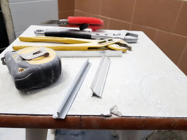 Repair - building with tools wrench, knife, iron knife, adjustable wrench and tape measure on a stool