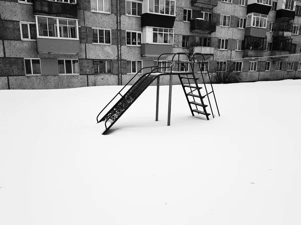 Plac zabaw dla dzieci obok domu zimą — Zdjęcie stockowe