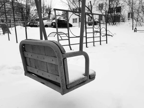 Parque infantil cerca de la casa en invierno - columpio —  Fotos de Stock