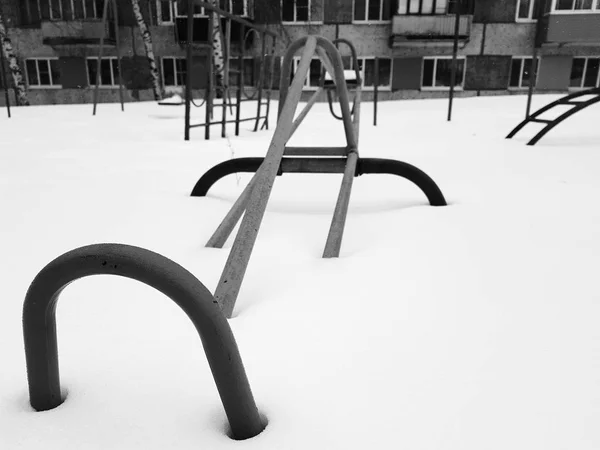 Дитячий майданчик біля будинку взимку - гойдалки — стокове фото
