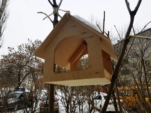 Una hermosa caja de anidación o alimentador de aves para el invierno en la nieve — Foto de Stock