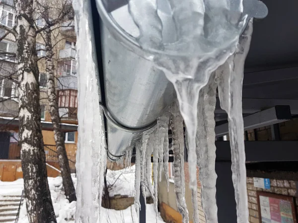 Grandi ghiaccioli pericolosi sopra l'ingresso della casa in inverno o in primavera contro la neve — Foto Stock