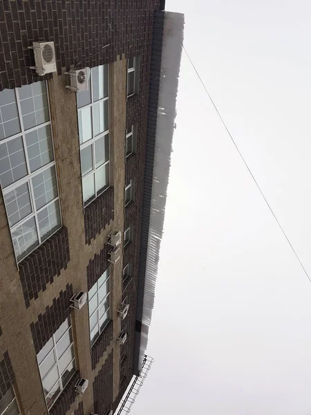 Dangerous ice block on the roof hangs in winter — Stock Photo, Image