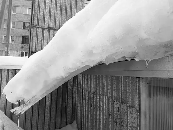 Peligroso bloque de hielo con nieve en el techo cuelga en el invierno — Foto de Stock