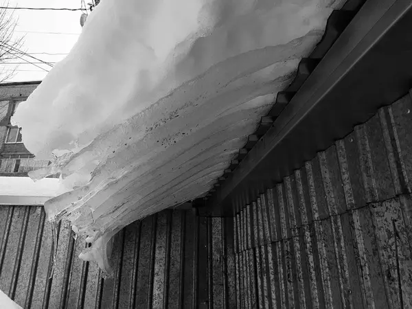 Bloco de gelo perigoso com neve no telhado pende no inverno — Fotografia de Stock