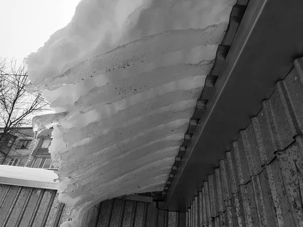 Blok lodu niebezpieczne ze śniegu na dachu wisi w zimie — Zdjęcie stockowe