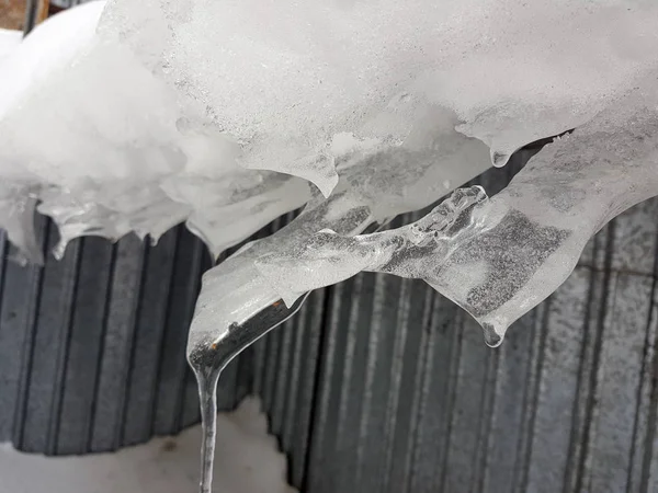 Peligroso bloque de hielo con nieve en el techo cuelga en el invierno —  Fotos de Stock