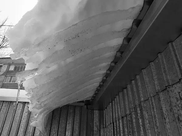 Blok lodu niebezpieczne ze śniegu na dachu wisi w zimie — Zdjęcie stockowe