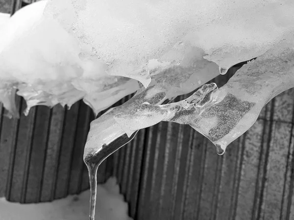 Dangerous ice block with snow on the roof hangs in the winter — Stock Photo, Image