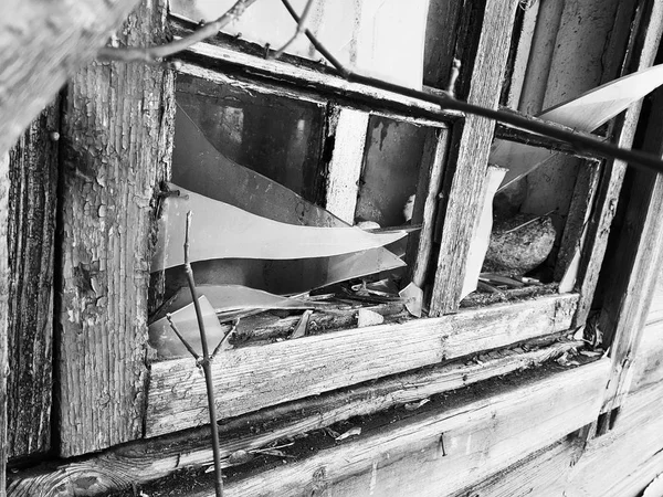 Панель с разбитым окном в старом доме на фоне снега зимой — стоковое фото