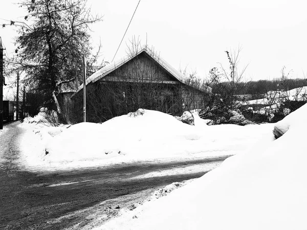 Kışın kar arka plan üzerinde kırık bir pencere ile eski terk edilmiş evde — Stok fotoğraf