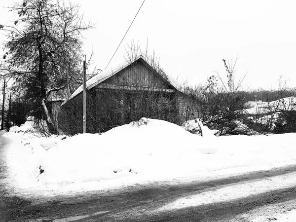 Antigua casa abandonada con una ventana rota en el fondo de la nieve en invierno —  Fotos de Stock