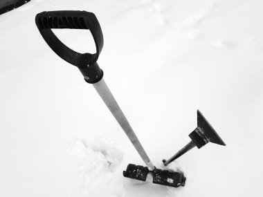 Kar küreği ve buz ax kışın karda sıkışmış