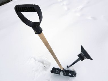 Kar küreği ve buz ax kışın karda sıkışmış