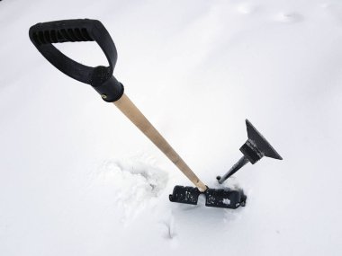 Kar küreği ve buz ax kışın karda sıkışmış