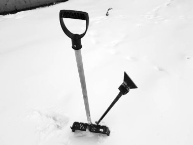 Kar küreği ve buz ax kışın karda sıkışmış
