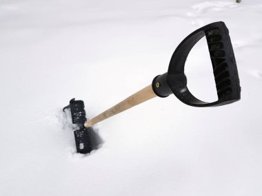Kar küreği ve buz ax kışın karda sıkışmış