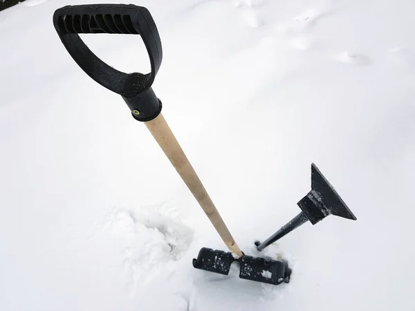 Snow shovel and ice ax stuck in the snow in winter — Stock Photo, Image