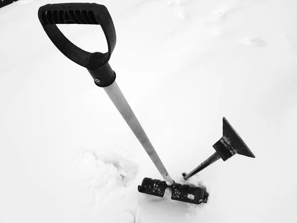 Lopata na sníh a LED ax uvízl ve sněhu v zimě — Stock fotografie