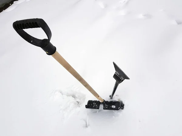 Snow shovel and ice ax stuck in the snow in winter — Stock Photo, Image