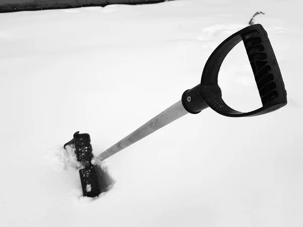 冬の雪の中で立ち往生している雪のシャベルとピッケル — ストック写真