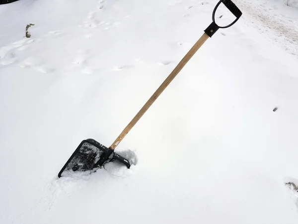 Snow shovel and ice ax stuck in the snow in winter — Stock Photo, Image