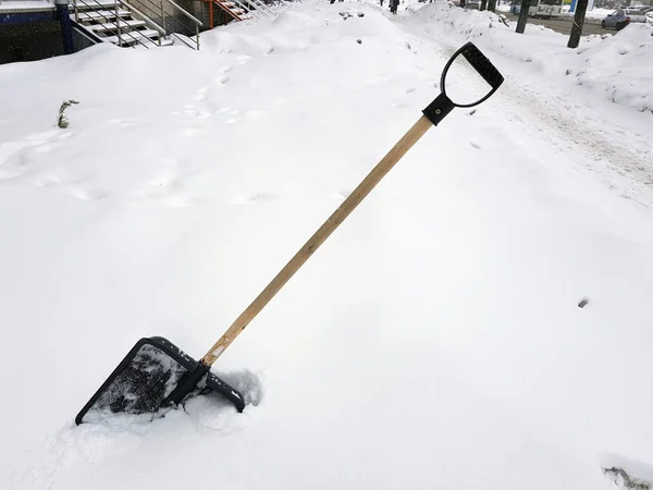 冬の雪の中で立ち往生している雪のシャベルとピッケル — ストック写真