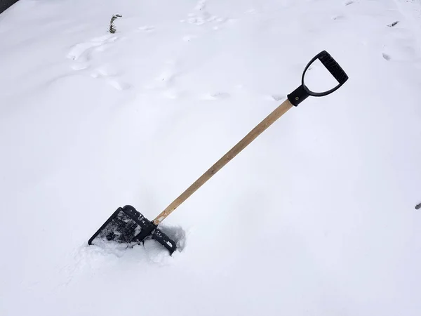 Snöskyffel och isyxa fastnat i snön i vinter — Stockfoto
