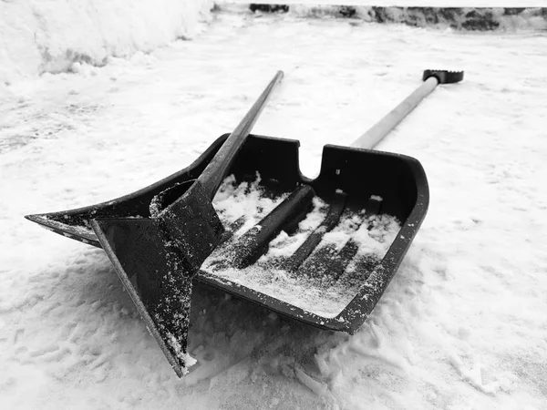 Snow shovel and ice ax lie on the snow in winter — Stock Photo, Image