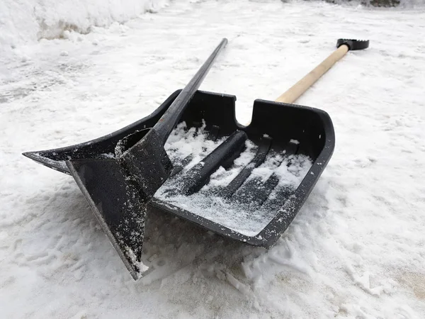 Snow shovel and ice ax lie on the snow in winter — Stock Photo, Image