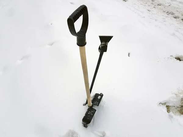 Snöskyffel och isyxa fastnat i snön i vinter — Stockfoto