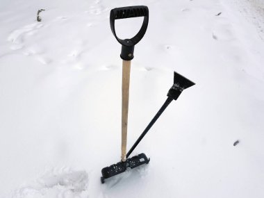 Kar küreği ve buz ax kışın karda sıkışmış