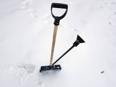Kar küreği ve buz ax kışın karda sıkışmış