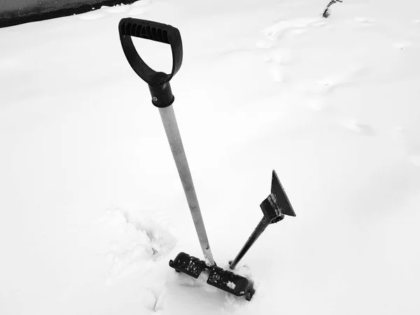 Pala da neve e piccozza bloccati nella neve in inverno — Foto Stock