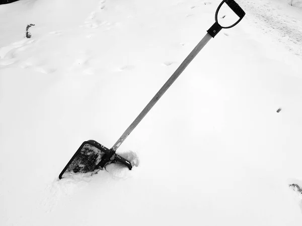 Снежная лопата и ледоруб зимой застряли в снегу. — стоковое фото