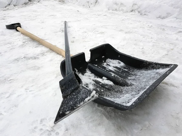Снежная лопата и ледоруб зимой лежат на снегу — стоковое фото