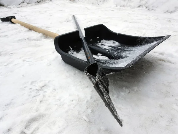 Snow shovel and ice ax lie on the snow in winter — Stock Photo, Image