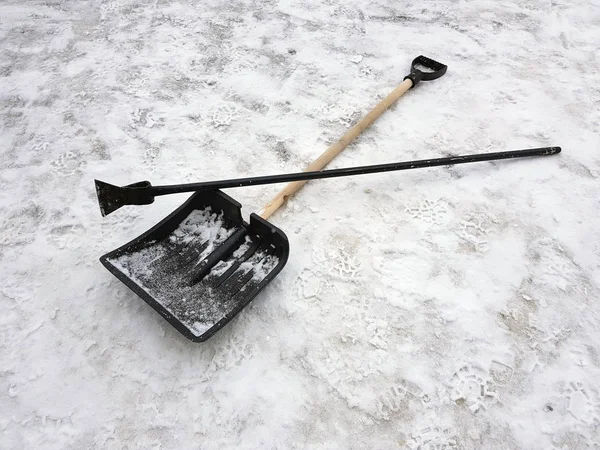 Schneeschaufel und Eispickel liegen im Winter im Schnee — Stockfoto