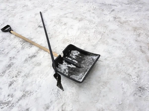 Pá de neve e machado de gelo jazem na neve no inverno — Fotografia de Stock