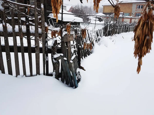 Красивий старий дерев'яний паркан на тлі снігу взимку — стокове фото