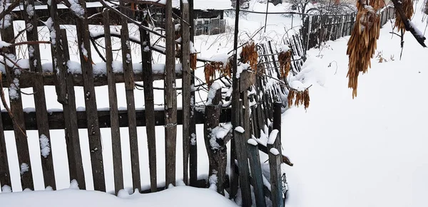 Hermosa cerca de madera vieja en el fondo de la nieve en invierno —  Fotos de Stock