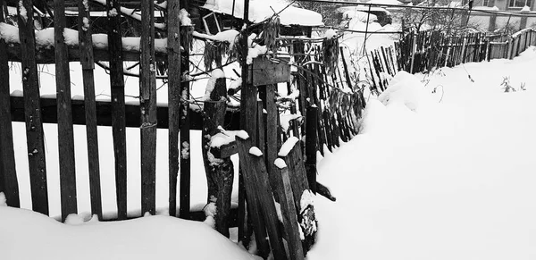 Beautiful old wooden fence on the background of snow in winter — Stock Photo, Image