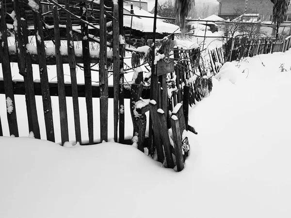 Schöner alter Holzzaun vor dem Hintergrund des Schnees im Winter — Stockfoto